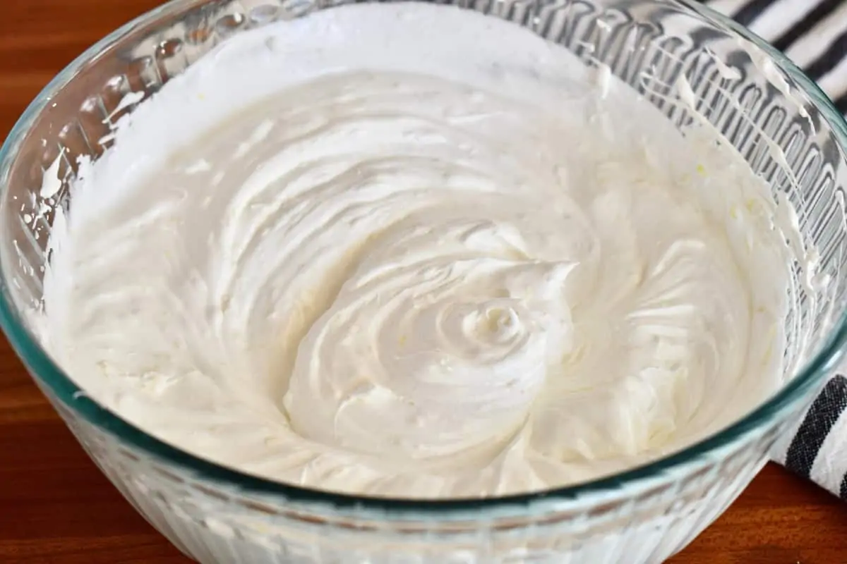 Batter of whipped egg whites in a glass bowl.