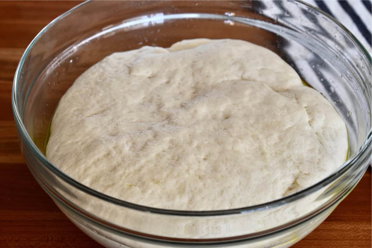Risen dough in a large glass bowl. 