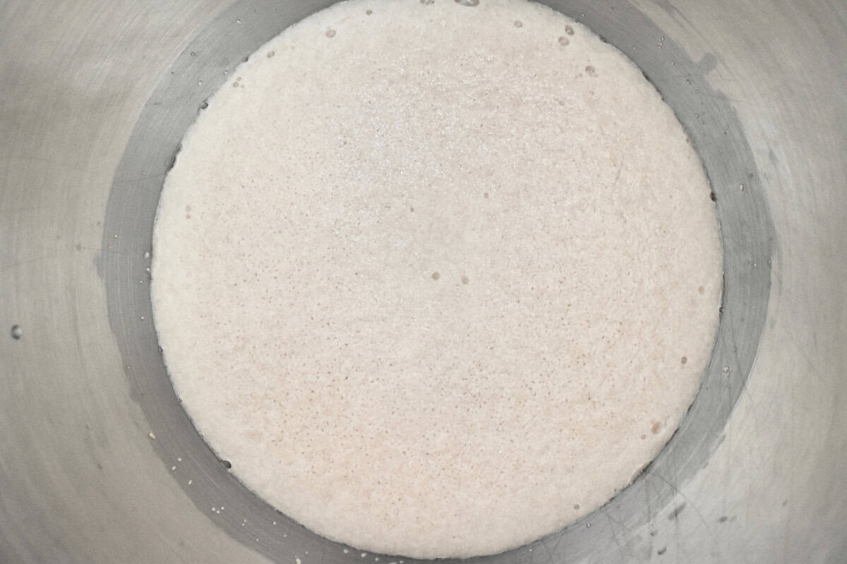 Yeast proofed in a large metal bowl. 