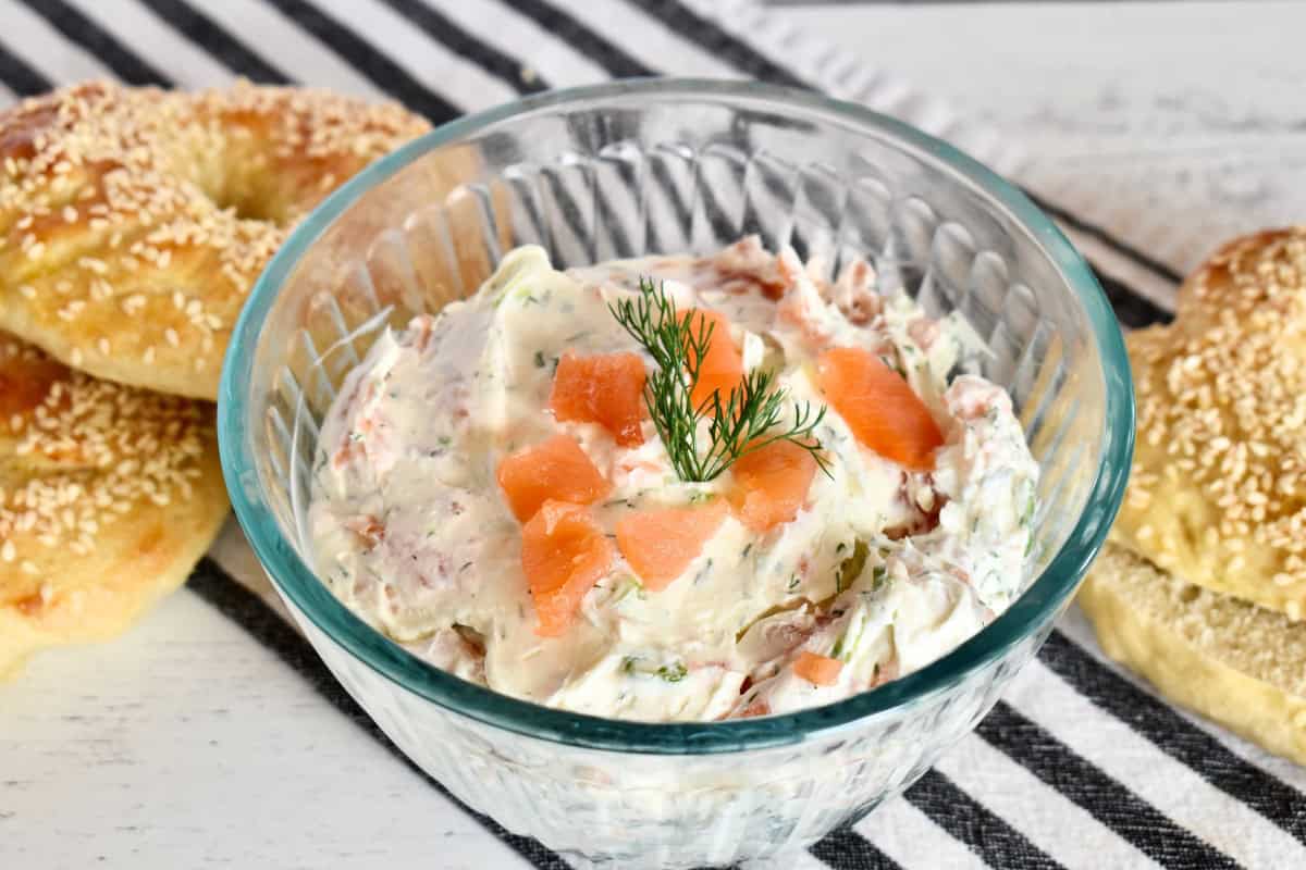 Smoked salmon cream cheese in a bowl with bagels next to it.
