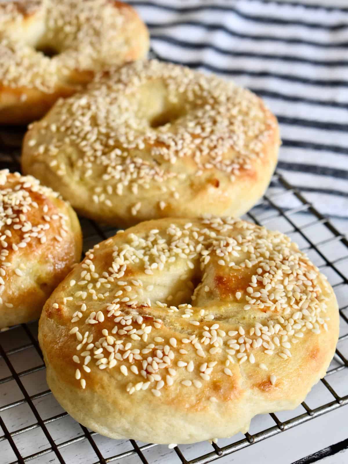 Sesame Seed Bagels on a wire cooling rack. 