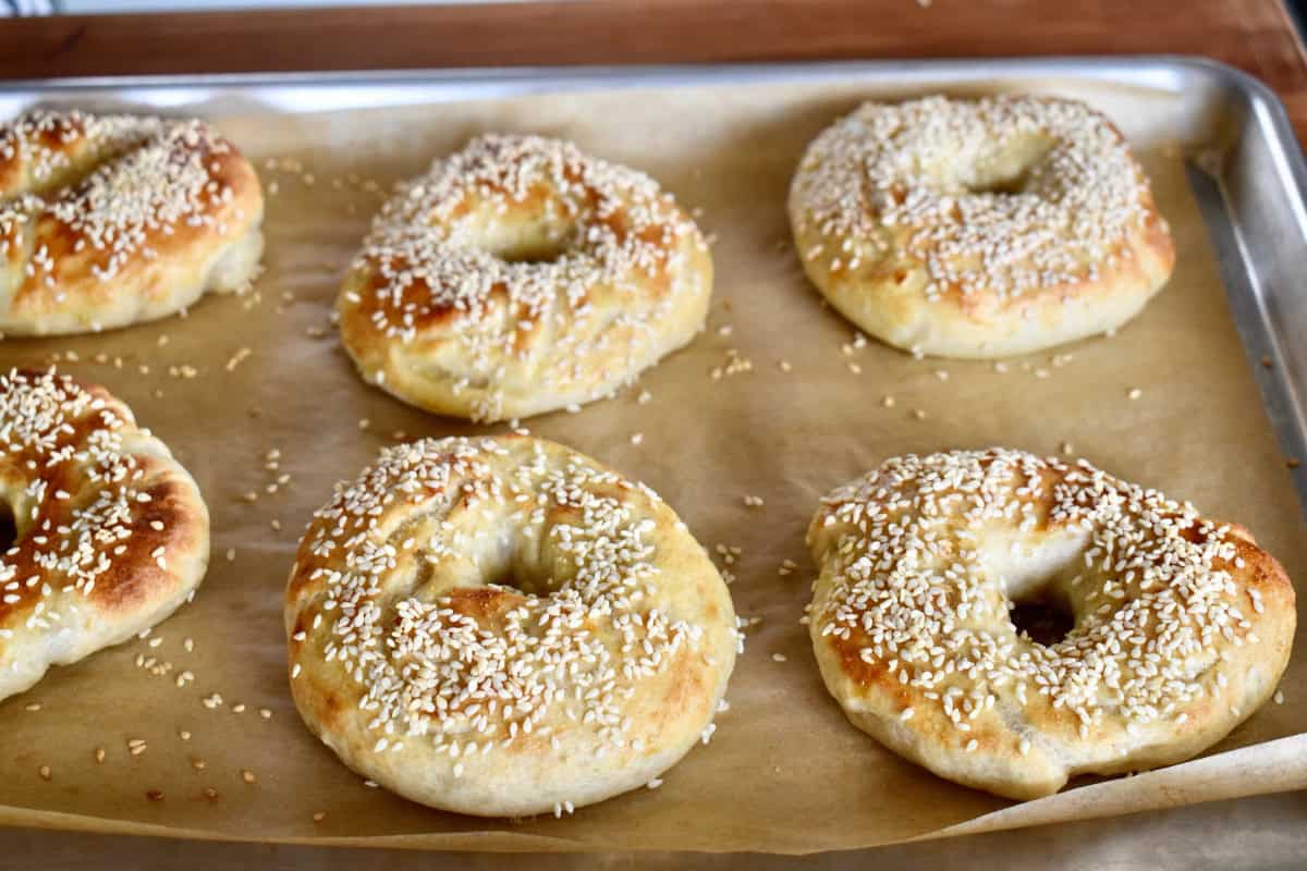 Baked Sesame Seed Bagels on a lined baking sheet. 