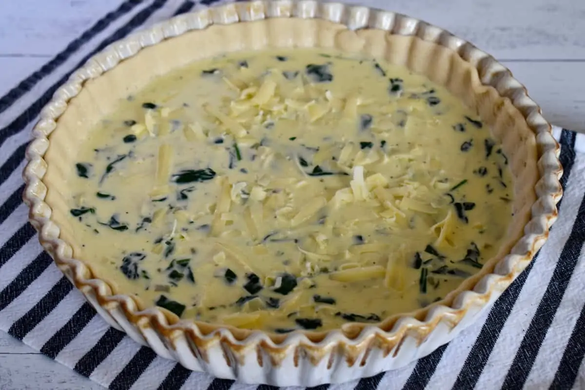 Egg filling ingredients poured into the prepared pan with store bought pie crust. 