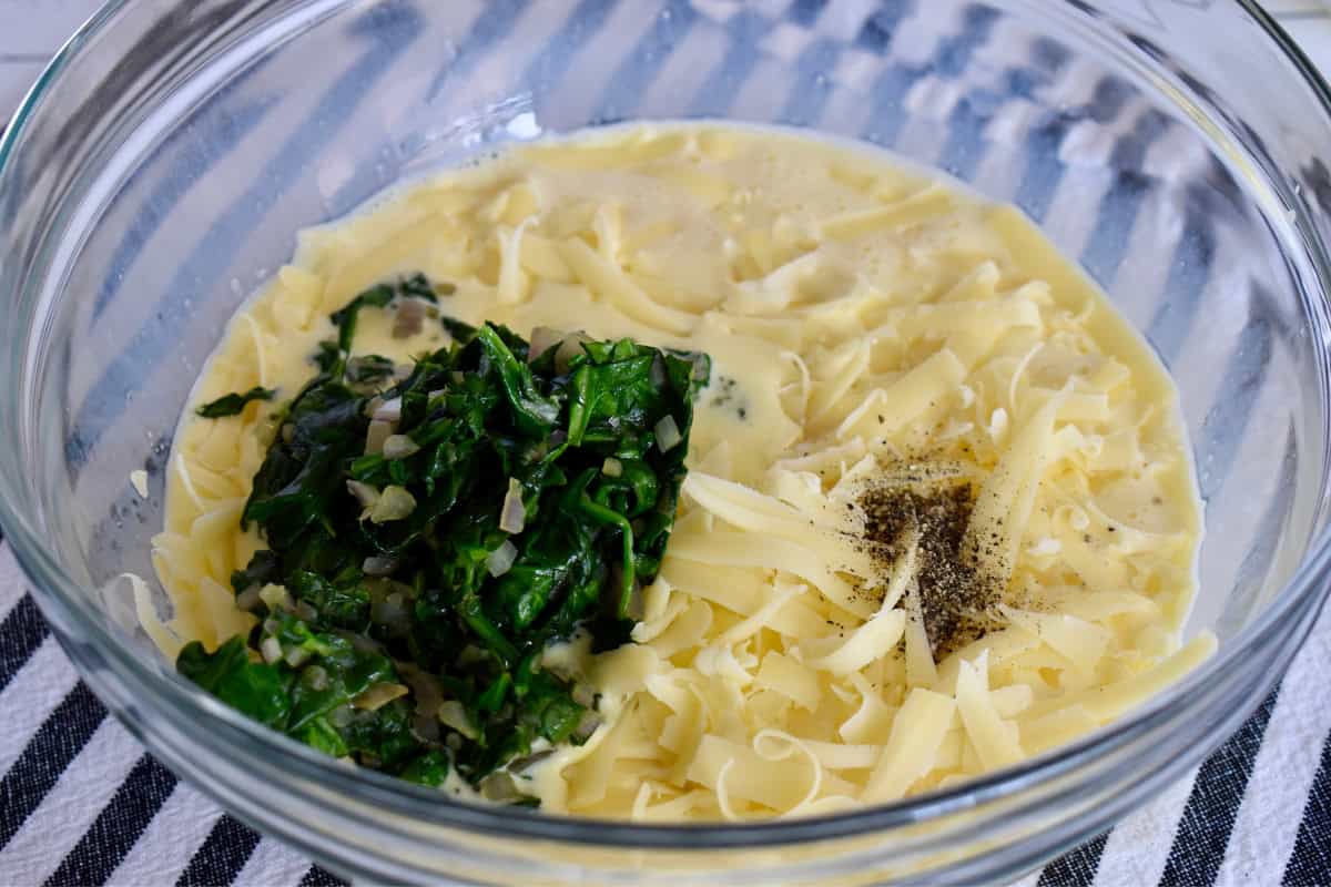 Egg, half and half, cheese, and cooked veggies in a large mixing bowl. 