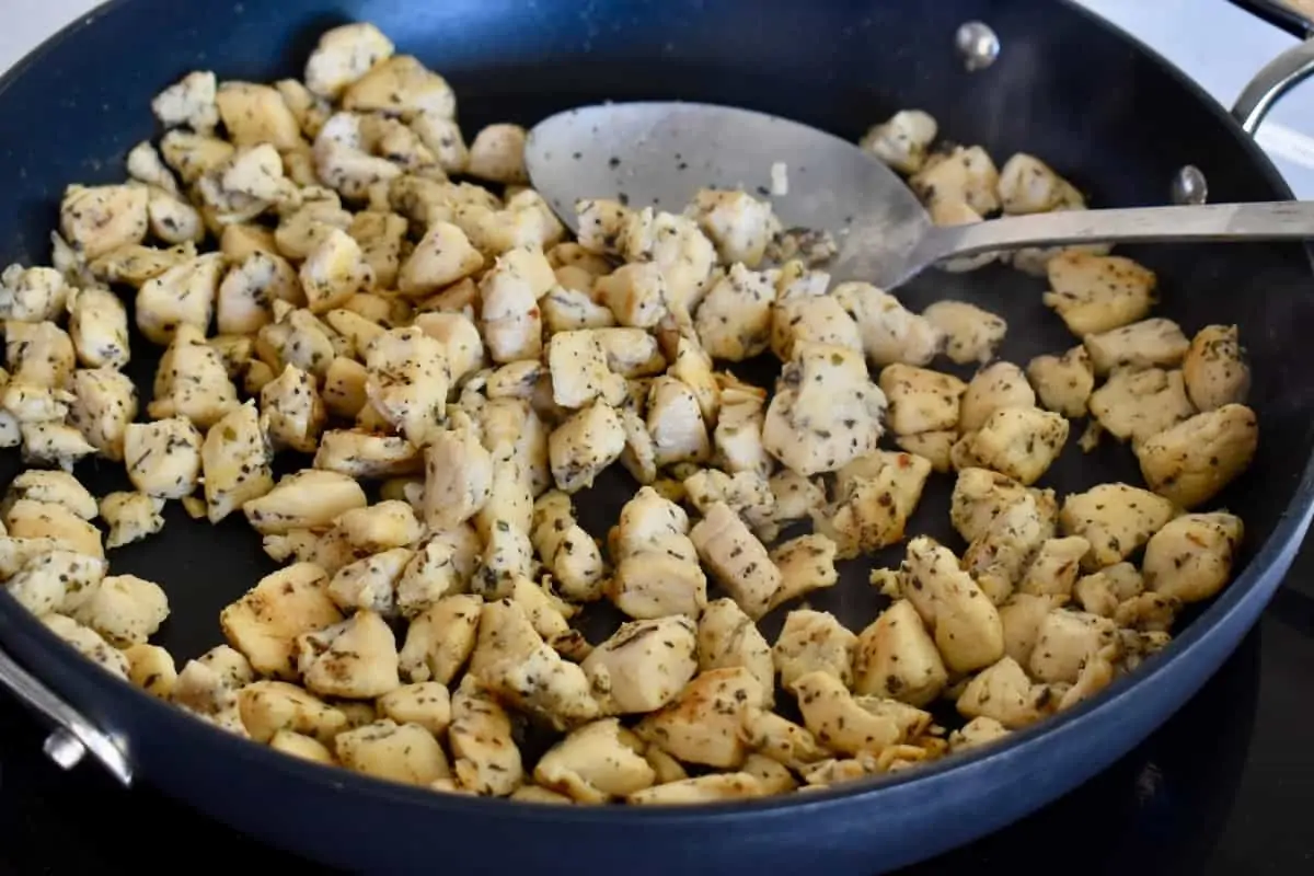 Cooked chicken pieces in a large skillet.