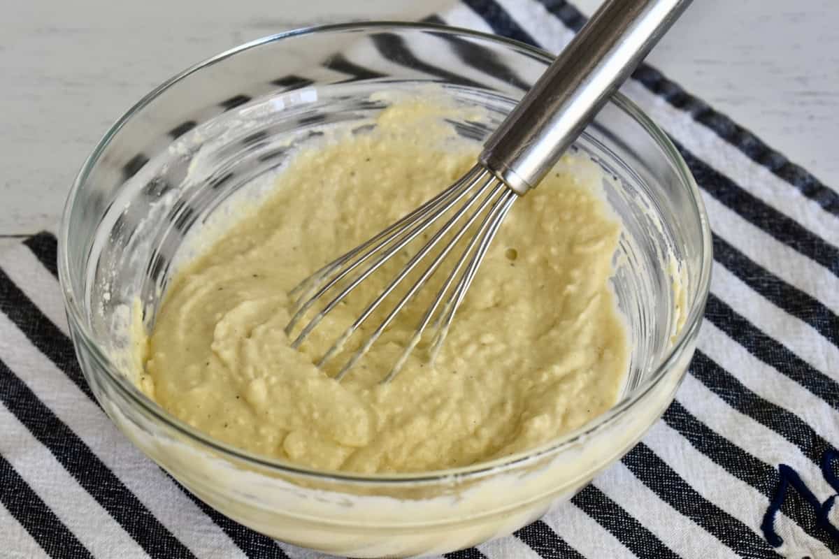 Dressing for recipe in a bowl with a whisk.