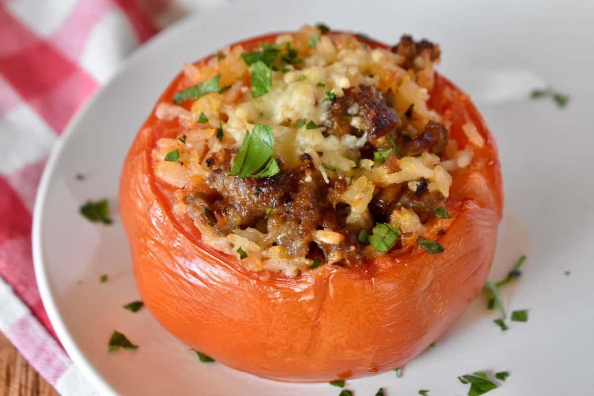 Baked Stuffed Tomato on a white plate.