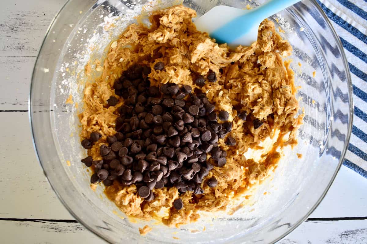 Ingredients in a mixing bowl with chocolate chips on top. 