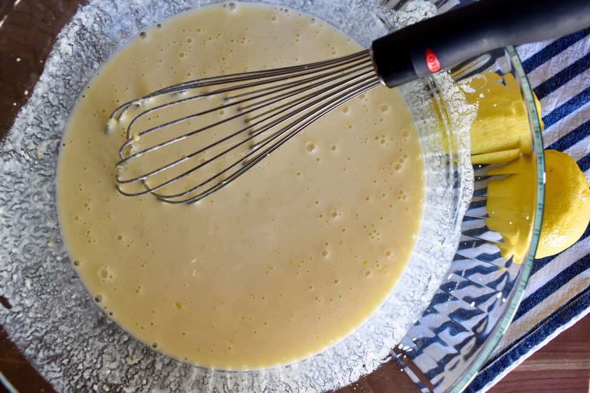 Batter in a large glass bowl with whisk.